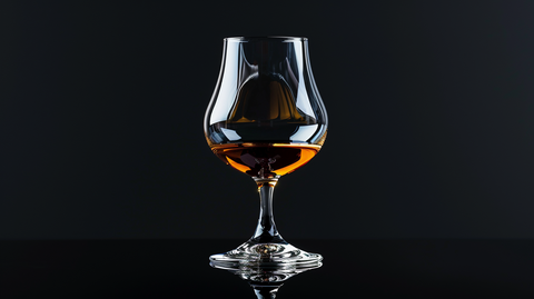 cognac glasse forme de tulipe dans un fond noir professionnel au milieu de l'image
